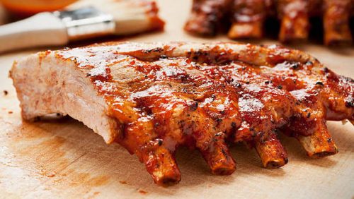 Barbecue ribs on a cutting board with sauce and brush.  Please see my portfolio for other food related images.