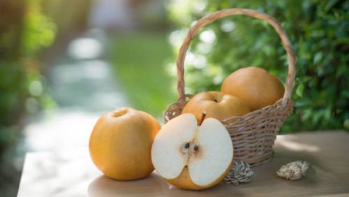 Snow pear or Fengsui pear on the brown wooden table in garden,Fresh Korea pear fruit. Korea pear fresh fruit in the basket  on natural farm background